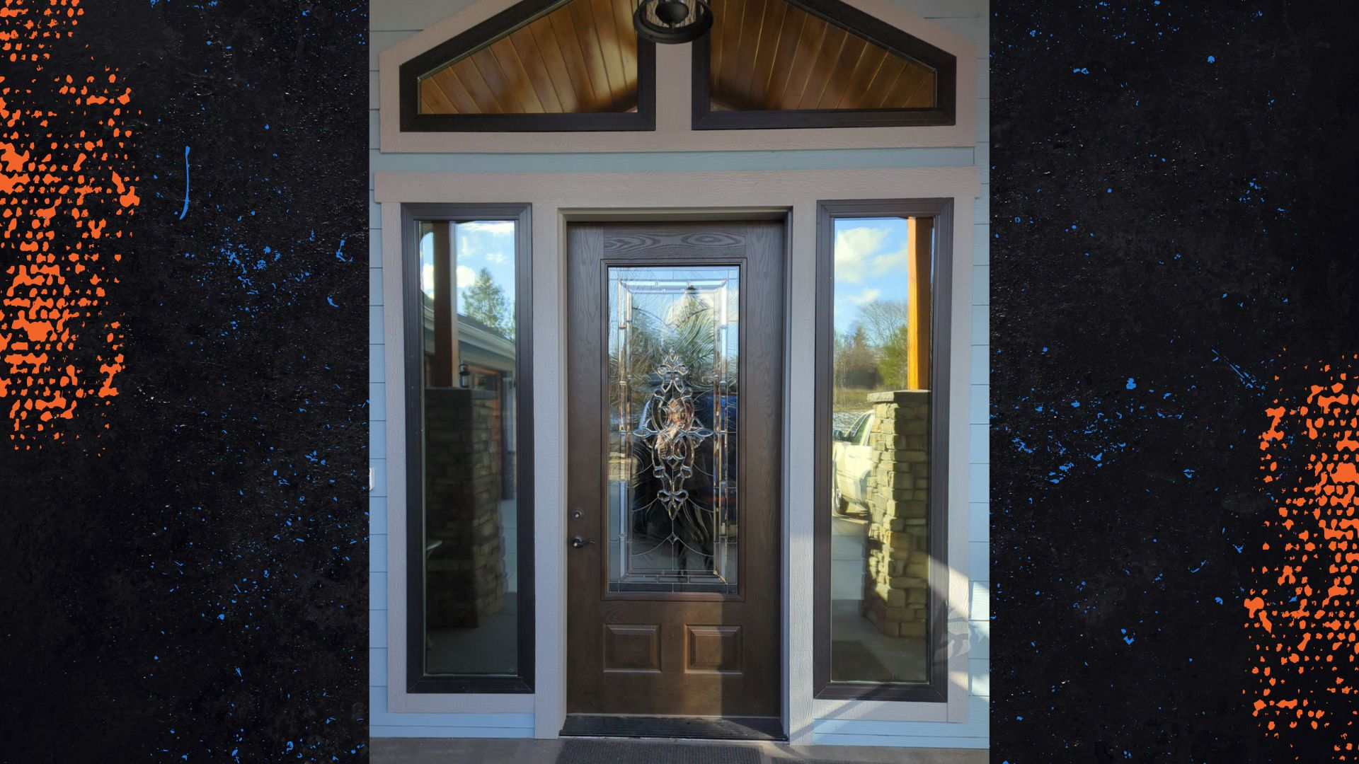 This image shows a stylish front door area with a peaked wood ceiling overhang and an elegant dark wood door with intricate glass design, framed by sidelight windows. The door reflects a serene outdoor scene, suggesting a calm and inviting entrance, while a modern security camera is visible to the left, adding a touch of technology.