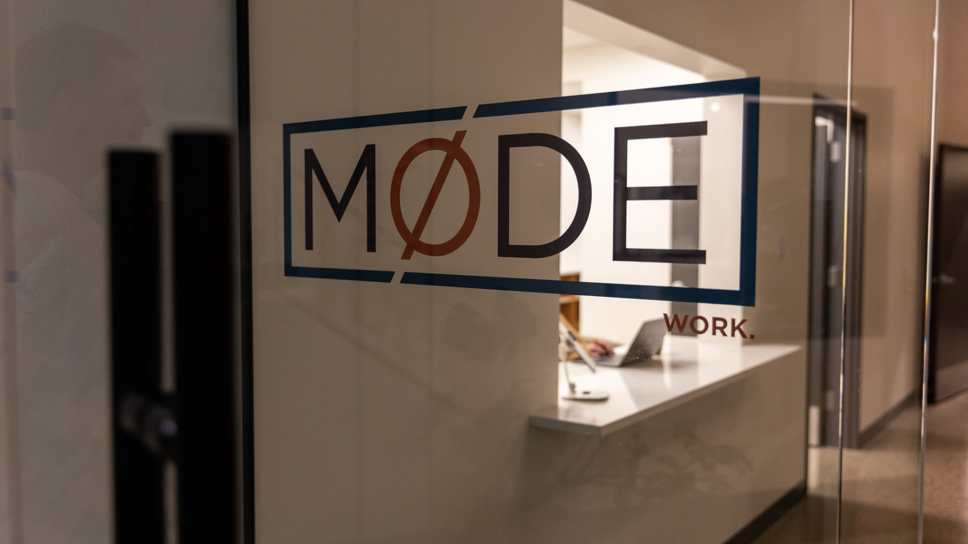 Mode company logo signage on office wall