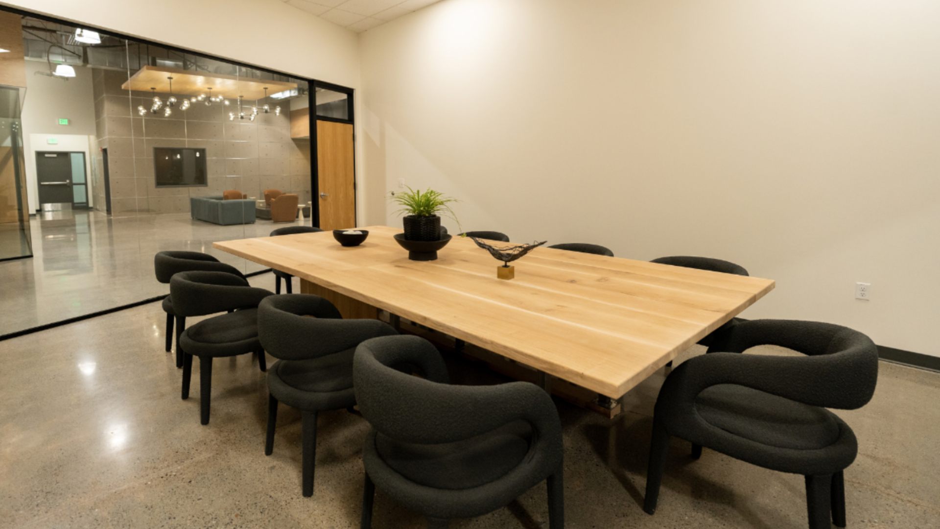 Conference room with long wooden table and black chairs